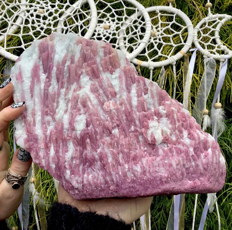 May include: A large, pink and white, raw, natural,  crystal slab with a striated pattern. The crystal is a variety of lepidolite.