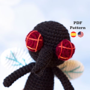 May include: Crochet amigurumi pattern for a black fly with red eyes and orange accents. The pattern is available in both English and Spanish. PDF Pattern.
