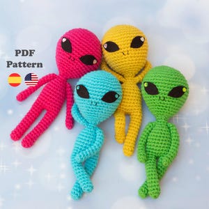 Puede incluir: Un grupo de cinco muñecos alienígenas de ganchillo de colores: rosa, amarillo, azul y verde. Cada muñeco tiene grandes ojos negros y una pequeña sonrisa. El texto "PDF Pattern" es visible en la esquina superior izquierda.