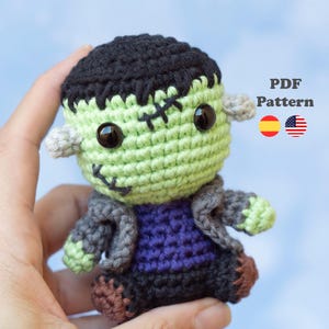 Puede incluir: Muñeco de Frankenstein tejido a crochet, con cara verde, pelo negro y detalles cosidos. El muñeco lleva una chaqueta gris y una camisa morada. Una encantadora decoración de Halloween. Incluye el texto "PDF Pattern".