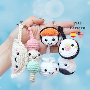 May include: A collection of handmade crochet food keychains, including sushi, dumplings, and dango. Each keychain features a smiling face and is attached to a silver keyring. The image includes the text "PDF Pattern" and flags for Spain and the United States.