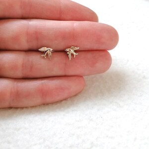 May include: A pair of silver swallow bird stud earrings. The earrings are small and delicate, and they are perfect for everyday wear.