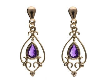 May include: A pair of gold dangle earrings with a purple amethyst gemstone in each. The earrings have a delicate, ornate design.