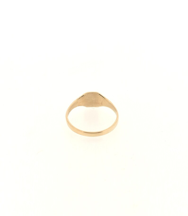 May include: A gold signet ring with a smooth, oval-shaped top.