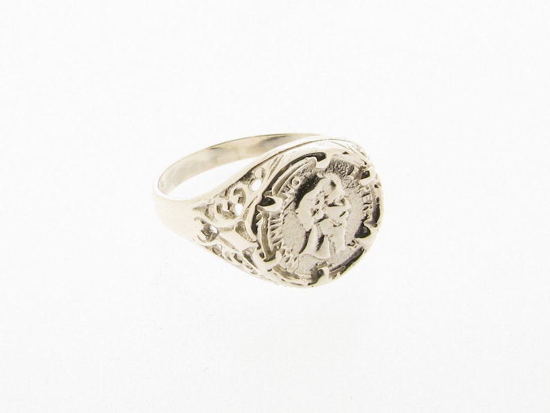 K&ouml;nnte beinhalten: Ein silberner Ring mit einem filigranen Design und einem runden, erhabenen Kamee mit dem Profil einer Person.