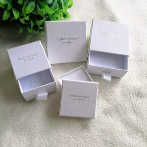 May include: Four white boxes with a drawer. Each box has the text "Stephen Knapper Jewellery" embossed on the top.