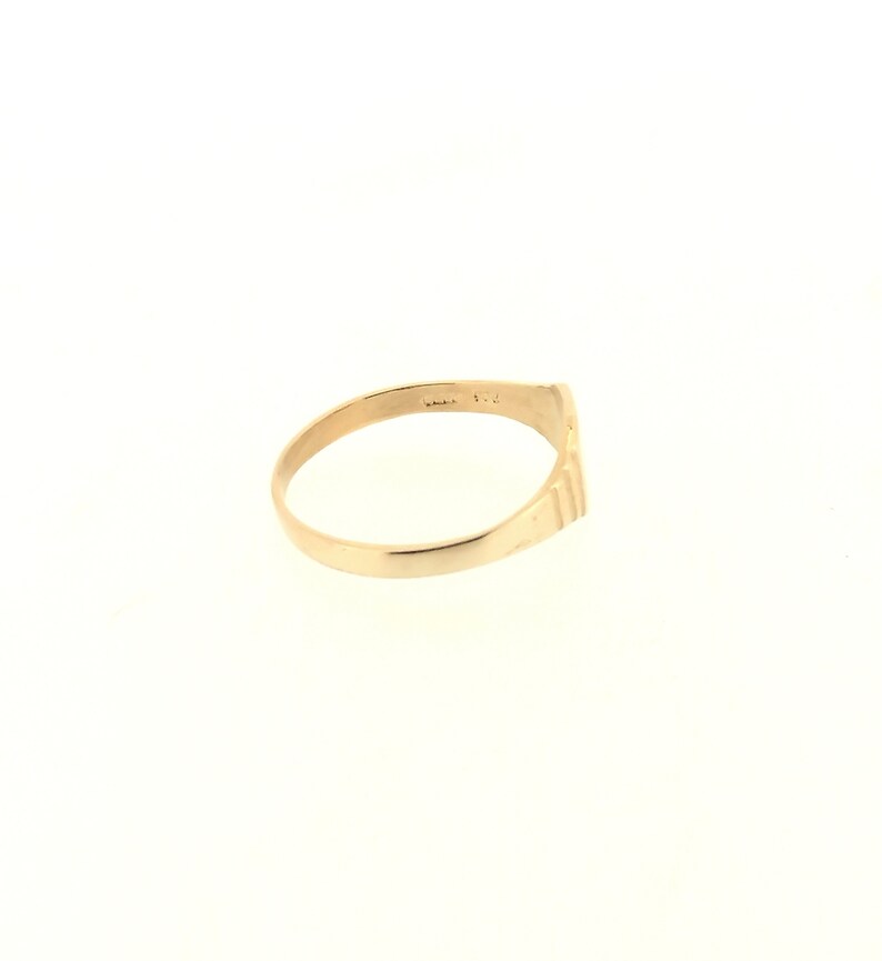 May include: A gold band ring with a textured design on the outside of the band.