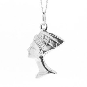 May include: Silver pendant necklace featuring a profile of an Egyptian queen wearing a headdress. The pendant is detailed with intricate patterns and is suspended from a silver chain.