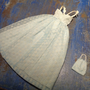 May include: A light blue dress with white floral embroidery and a matching light blue handbag. The dress has a sweetheart neckline and thin straps.