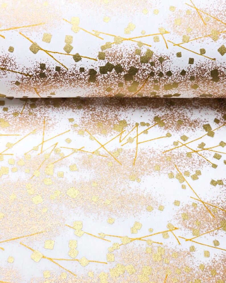 Japanese chiyogami paper featuring scattered metallic gold geometric shapes and fine gold lines on a white background.