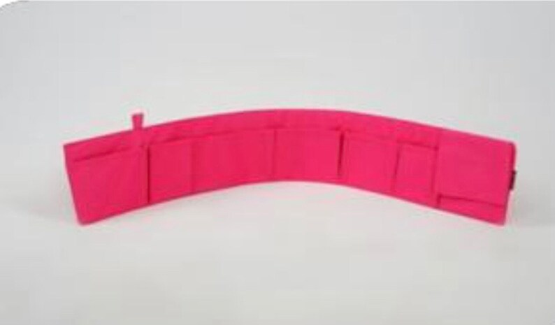 Pu&ograve; includere: Un portafoglio in tessuto rosa con pi&ugrave; scomparti e una chiusura a zip.