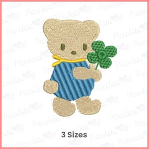 Op de afbeelding: Een bruine teddybeer met een blauw-wit gestreept shirt en een gele sjaal houdt een groene vierbladige klaver vast. De afbeelding bevat de tekst "3 maten".