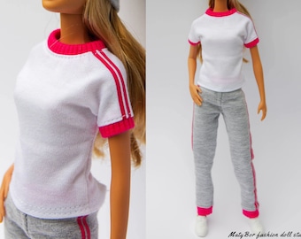 May include: A white t-shirt with pink trim and grey sweatpants with pink stripes. The t-shirt has a crew neck and short sleeves.