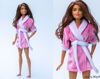 May include: A pink and white bathrobe with a white trim and a white sash. The robe is made of a soft, plush material.