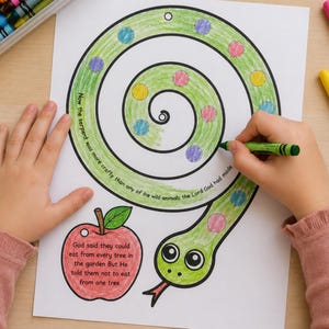 May include: A child coloring a green snake illustration with a green crayon. The snake has colorful dots and is next to a red apple. Text on the page reads, "Now the serpent was more crafty than any of the wild animals the Lord God had made."