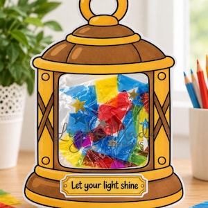 May include: A printable lantern craft featuring a brown and yellow frame with a central window filled with colorful translucent paper and star cutouts. A label at the bottom reads Let your light shine. The top banner text reads Printable Let Your Light Shine Lantern Craft.