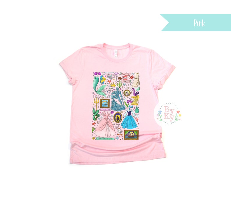 Pu&ograve; includere: Maglietta rosa con una stampa grafica colorata di vari personaggi e simboli di principesse Disney. La grafica include Ariel, Cenerentola e altri personaggi. Il testo sulla grafica include "Part of Your World" e "Happily Ever After".