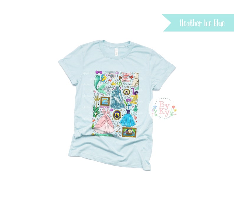 Pu&ograve; includere: Una maglietta blu chiaro con una stampa grafica colorata di vari personaggi e simboli di principesse e sirene Disney. La grafica include Ariel, Cenerentola e altri personaggi dei film Disney.