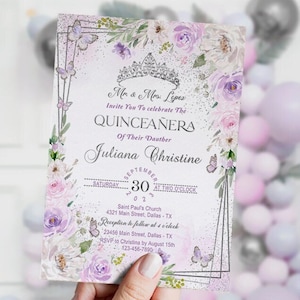 Puede incluir: Una invitación de Quinceañera floral de color morado y blanco con un fondo de brillo plateado. La invitación presenta una corona plateada, mariposas y el texto "Mr. & Mrs. Lopez Invite You To Celebrate The Quinceañera Of Their Daughter Juliana Christine". La invitación mide 12,7 x 17,8 cm.