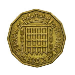 May include: A gold-colored three pence coin from the United Kingdom, featuring a crown and the words "THREE PENCE" around the edge. The year 1953 is inscribed on the bottom.