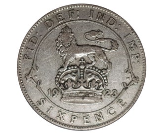 May include: A 1923 Sixpence coin, silver in colour, with a crowned lion motif and the inscription "FID. DEF. IND. IMP." around the rim. The coin's face also displays the year of issue and the value.
