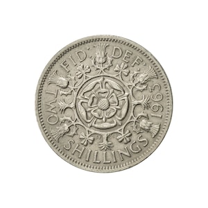 May include: A silver two shilling coin from 1963 with the inscription "TWO SHILLINGS" and "FID. DEF." around the edge. The center of the coin features a rose with a crown and other floral designs.