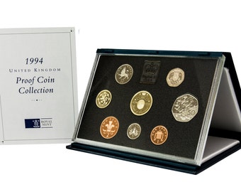 May include: A 1994 United Kingdom Proof Coin Collection in a black and blue display case. The case contains a set of 8 coins, including a 50 pence coin with a design of a flock of birds.