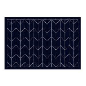 Op de afbeelding: Een donkerblauw tapijt met een wit chevronpatroon. Het tapijt heeft een subtiele glans en een zachte textuur.