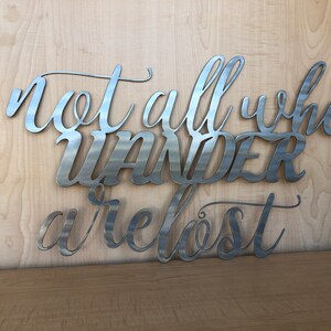 May include: Metal wall art with the quote "Not all who wander are lost".