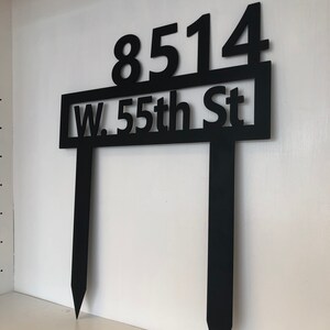 May include: Black metal yard sign with the address "8514 W. 55th St" and two stakes.