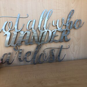 May include: Metal wall art with the quote "Not all who wander are lost".