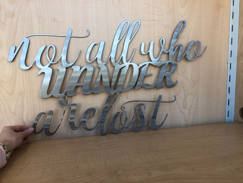 May include: Metal wall art with the quote "Not all who wander are lost".
