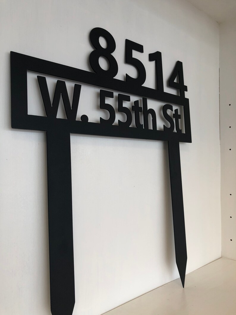 May include: Black metal house number sign with the numbers 8514 and the text "W. 55th St" on a white background.