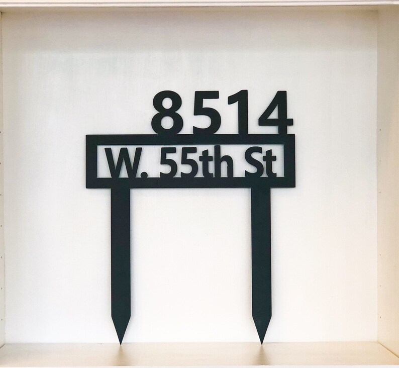 May include: Black metal house number sign with the address "8514 W. 55th St" on a white background.