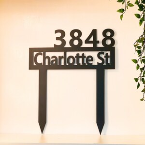 May include: Black metal yard sign with the address 3848 Charlotte St.