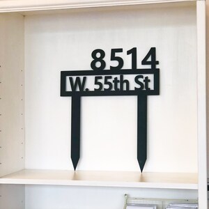 May include: Black metal house number sign with the address 8514 W. 55th St.