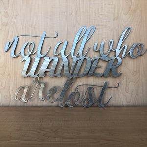 May include: Metal wall art with the quote "Not all who wander are lost".