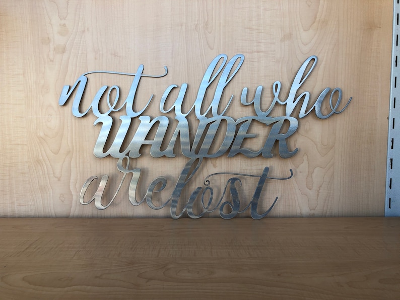 May include: Metal wall art with the quote "Not all who wander are lost".