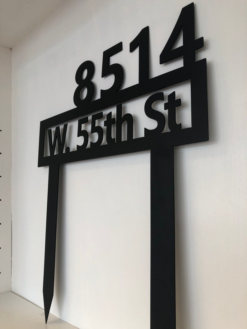 May include: Black metal yard sign with the address "8514 W. 55th St" in white lettering.