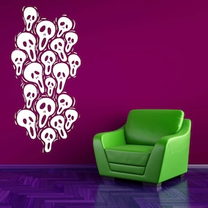 May include: White skull wall decal on a deep magenta wall. The decal features a cluster of stylized skulls with open mouths. A green armchair sits in the corner, and the floor is a dark purple wood pattern.
