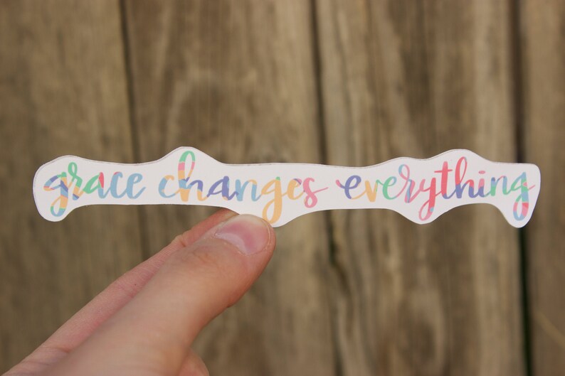May include: A white sticker with the text "grace changes everything" written in colorful script.