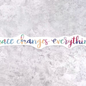 May include: A colorful sticker with the text "grace changes everything" in a white background.