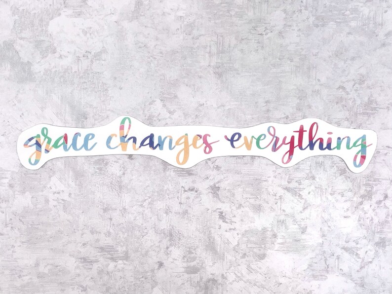 May include: A colorful sticker with the text "grace changes everything" in a white background.