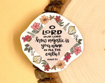 May include: A white square sticker with a floral border and a pink background. The text on the sticker reads "O LORD OUR LORD how majestic is your name IN ALL THE earth! PSALM 8:1"