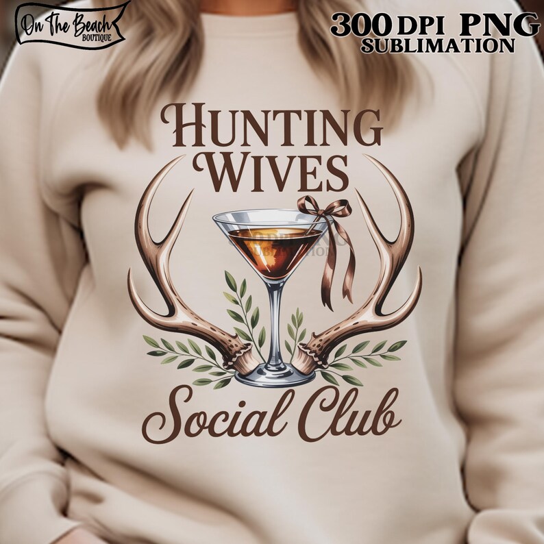 May include: A beige sweatshirt with the text "Hunting Wives Social Club" in brown script. The design includes a martini glass, antlers, and greenery. The top right corner has the text "300 DPI PNG SUBMLIMATION". The top left corner has the text "On The Beach Boutique".