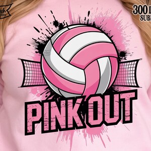 Op de afbeelding: Roze sweatshirt met een volleybalontwerp met roze en witte panelen, tegen een roze spetterachtergrond. De woorden "PINK OUT" zijn gedrukt in vette, roze letters. Het sweatshirt heeft ook de tekst "300DPI PNG SUBMLIMATION".