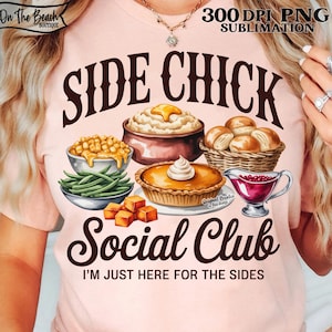 May include: A light pink t-shirt with a graphic design featuring the words "SIDE CHICK Social Club" and the phrase "I'M JUST HERE FOR THE SIDES." The design includes illustrations of various side dishes like mashed potatoes, pie, and rolls.