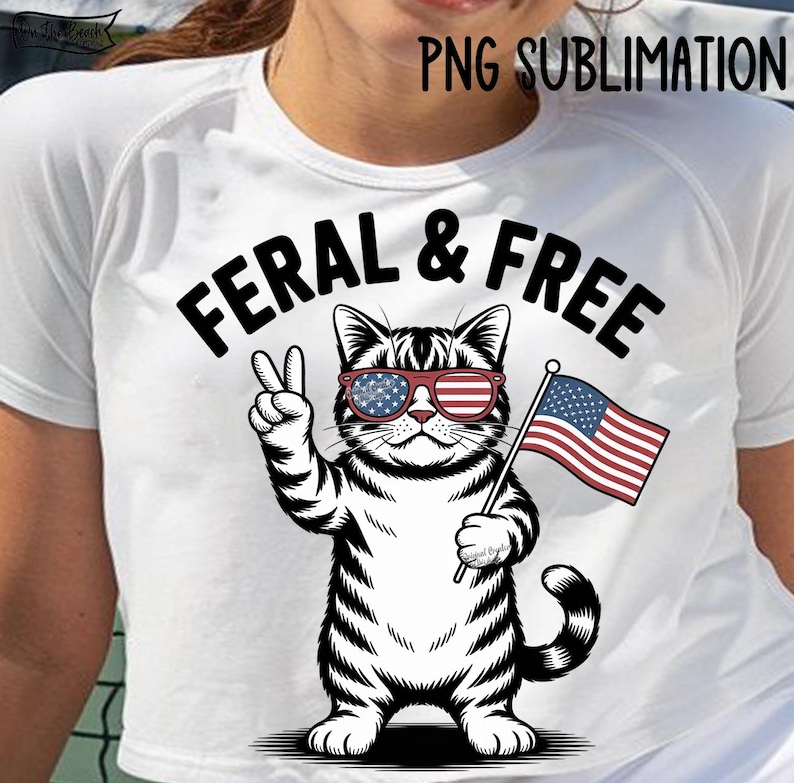 May include: White t-shirt featuring a black and white illustration of a cat wearing sunglasses with an American flag design and holding a small American flag. The text "FERAL & FREE" is above the cat.