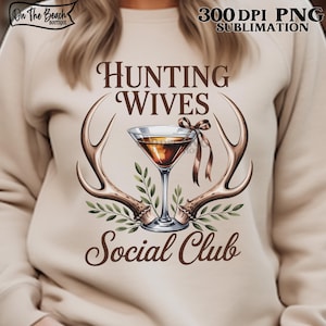 May include: A beige sweatshirt with the text "Hunting Wives Social Club" in brown script. The design includes a martini glass, antlers, and greenery. The top right corner has the text "300 DPI PNG SUBMLIMATION". The top left corner has the text "On The Beach Boutique".