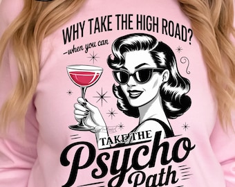 May include: Pink sweatshirt with a graphic of a woman in sunglasses holding a cocktail. Text reads "WHY TAKE THE HIGH ROAD? -when you can TAKE THE Psycho Path". The design includes stars and the words "300 DPI PNG SUBLIMATION".